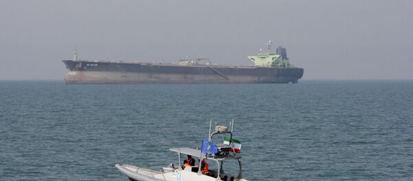 In this July 2, 2012 file photo, an Iranian Revolutionary Guard speedboat moves in the Persian Gulf while an oil tanker is seen in background - Sputnik Türkiye