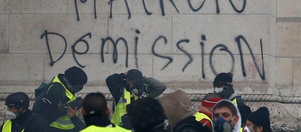 Sarı Yelekler hareketi, talepleri arasında yer alan Macron'un istifasını Paris'teki Zafer Takı'na da yazdı. - Sputnik Türkiye