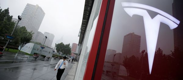 A man walks near a logo of Tesla outside its China headquarters at China Central Mall in Beijing, China July 11, 2018 - Sputnik Türkiye