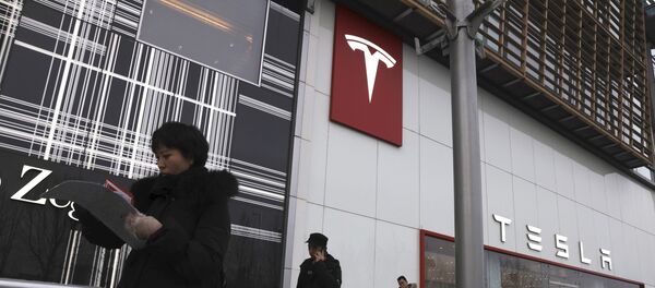 Residents walk past a Tesla store in Beijing Residents walk past a Tesla store in Beijing - Sputnik Türkiye