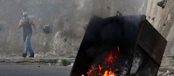 Caracas'ta isyan girişiminde bulunan askeri birliğe yakın Cotiza mahallesinde yaşayanlar tencere tava çalıp çöp konteynerlerini ateşe verdi ve güvenlik güçlerine taş attı. - Sputnik Türkiye