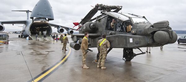 An AH-64 Apache attack helicopter stands in front of a Galaxy C-5 transport plane at the US Air Base in Ramstein, western Germany, February 22, 2017. - Sputnik Türkiye