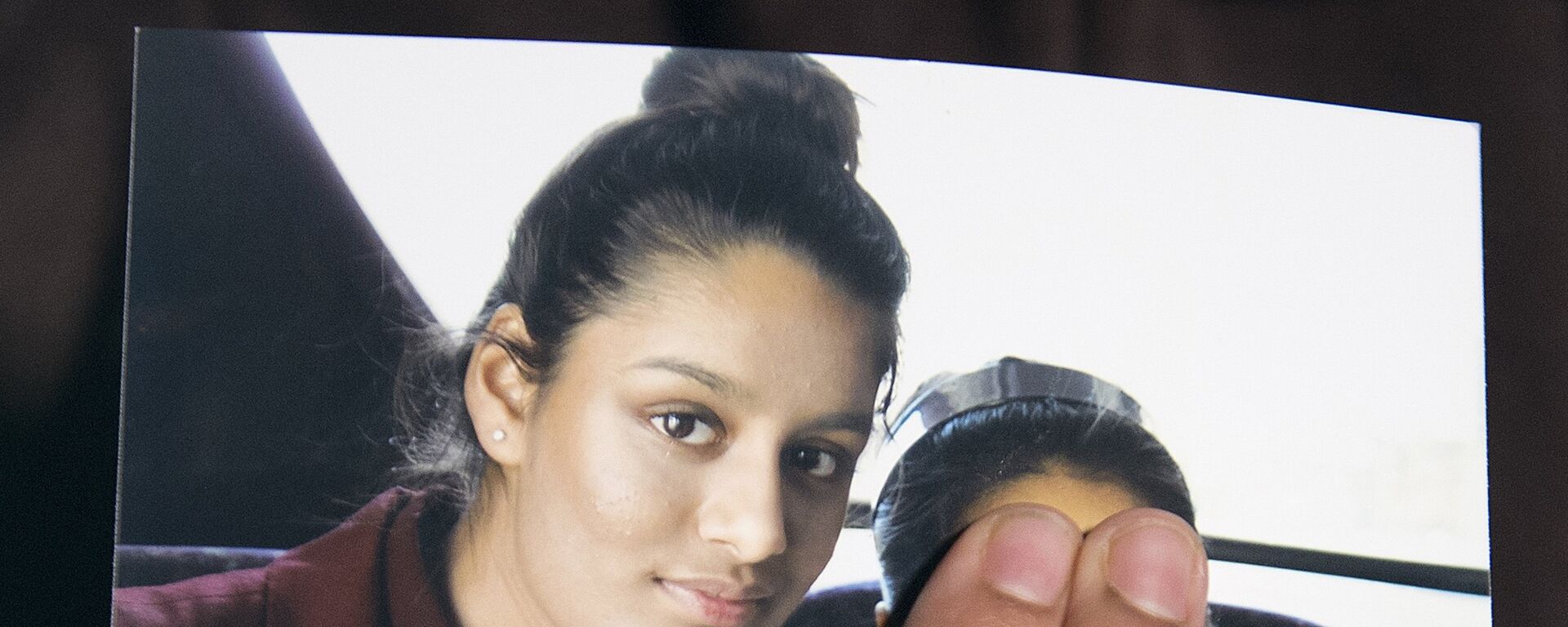 In this file photo taken on February 22, 2015 Renu Begum, eldest sister of missing British girl Shamima Begum, holds a picture of her sister while being interviewed by the media in central London - Sputnik Türkiye, 1920, 31.08.2022