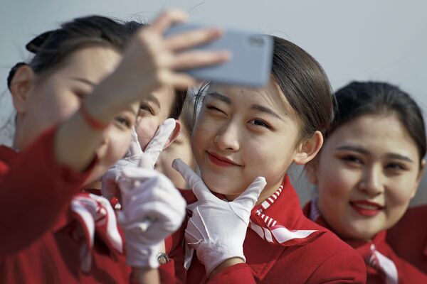 Pekin'de düzenlenen Çin Ulusal Halk Kongresi'nin (ÇUHK) oturumlarına katılan delegeleri karşılayan ulusal kıyafetli hostes kızları. - Sputnik Türkiye