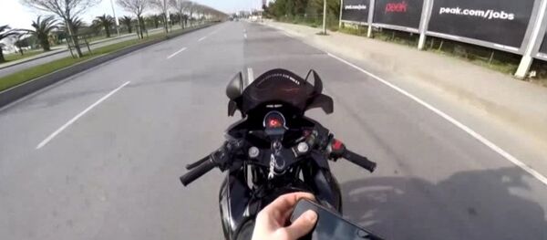 seyir halinde deposuna benzin dolduran motosiklet sürücüsü - Sputnik Türkiye