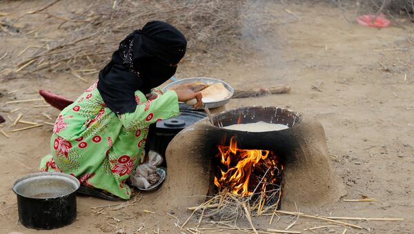 Yemen'in kuzeybatısındaki Hacca eyaletinin Abs kenti yakınında savaşta evsiz, yersiz kalanların oluşturduğu kampta bir kadın elde olanlarla yemek pişirmeye çalışıyor. - Sputnik Türkiye