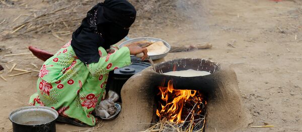 Yemen'in kuzeybatısındaki Hacca eyaletinin Abs kenti yakınında savaşta evsiz, yersiz kalanların oluşturduğu kampta bir kadın elde olanlarla yemek pişirmeye çalışıyor. - Sputnik Türkiye