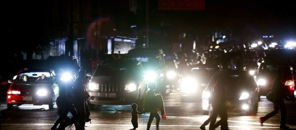 Residents cross a street in the dark after a power outage in Caracas, Venezuela, Thursday, March 7, 2019. A power outage left much of Venezuela in the dark early Thursday evening in what appeared to be one of the largest blackouts yet in a country where power failures have become increasingly common. Crowds of commuters in capital city Caracas were walking home after metro service ground to a halt and traffic snarled as cars struggled to navigate intersections where stoplights were out. - Sputnik Türkiye