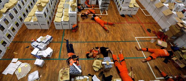 Endonezya'daki dünyanın en büyük tek günlük seçimi öncesinde, sandık materyallerini hazırlayan işçiler başkent Jakarta'da mola sırasında dinleniyor. - Sputnik Türkiye