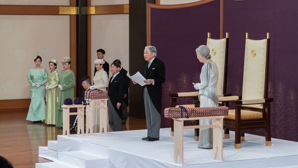 Akihito, solunda veliaht oğlu Naruhito,  sağında eşi İmparator Michiko, tahtı bırakma konuşmasını yaparken - Sputnik Türkiye