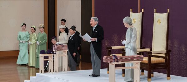 Akihito, solunda veliaht oğlu Naruhito,  sağında eşi İmparator Michiko, tahtı bırakma konuşmasını yaparken - Sputnik Türkiye