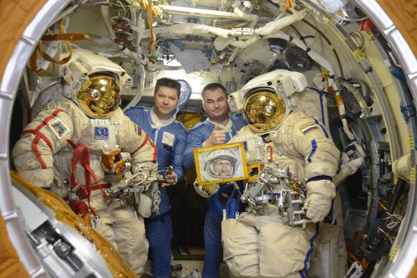 Oleg Kononenko ve Aleksey Ovçinin, 30 Mayıs’ta 85. yaş gününü kutlayan uzayda yürüyen ilk insan Aleksey Leonov’un portresiyle. - Sputnik Türkiye