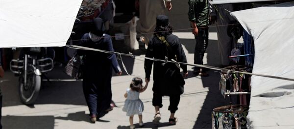 İdlib'in güneyinde eşi ve çocuğuyla pazarda gezen bir cihatçı militan - Sputnik Türkiye