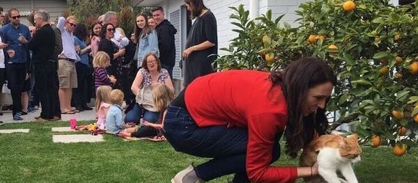 Yeni Zelanda Başbakanı Jacinda Ardern bahçede kedisi Paddles ile  - Sputnik Türkiye