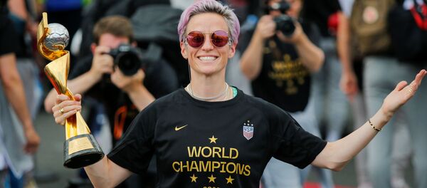 Megan Rapinoe smiles as she holds the Trophy for the FIFA Women's World Cup while the U.S. team arrive at the Newark International Airport, in Newark, New Jersey, U.S., July 8, 2019. REUTERS/Eduardo Munoz Megan Rapinoe smiles as she holds the Trophy for the FIFA Women's World Cup while the U.S. team arrive at the Newark International Airport, in Newark, New Jersey, U.S., July 8, 2019. REUTERS/Eduardo Munoz - Sputnik Türkiye