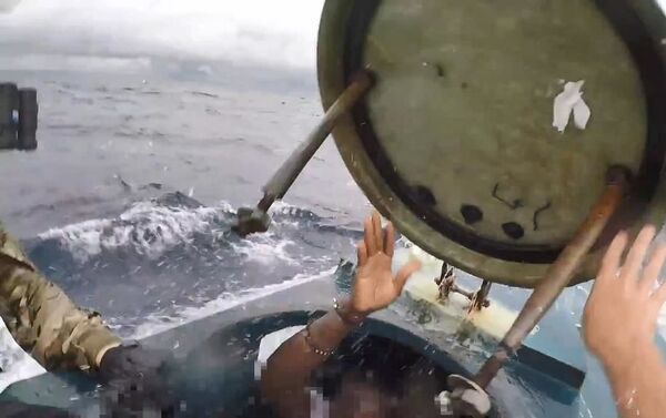 Sahip güvenlik ekiplerinin kamerasınca görüntülenen olayda, ekip komutanının, denizaltında bulunan kaçakçılara seslendiği; ardından sürat teknesiyle yaklaşan ekipleri denizaltının üzerine atladığı görüldü. - Sputnik Türkiye