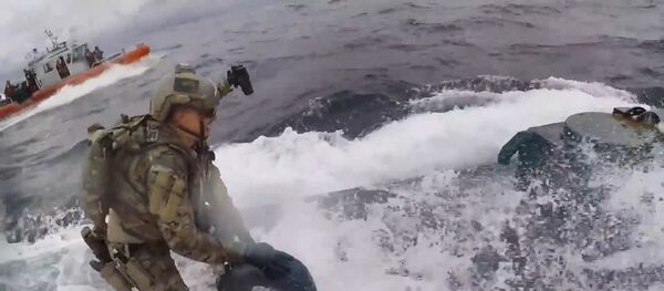 Sahip güvenlik ekiplerinin kamerasınca görüntülenen olayda, ekip komutanının, denizaltında bulunan kaçakçılara seslendiği; ardından sürat teknesiyle yaklaşan ekipleri denizaltının üzerine atladığı görüldü. - Sputnik Türkiye