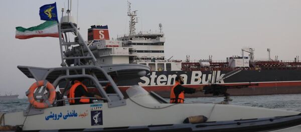 A boat of Iranian Revolutionary Guard sails next to Stena Impero, a British-flagged vessel owned by Stena Bulk, at Bandar Abbas port, in this undated handout photo. Iran, ISNA/WANA Handout via REUTERS ATTENTION EDITORS - THIS IMAGE WAS PROVIDED BY A THIRD PARTY. - Sputnik Türkiye