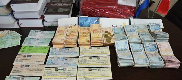 Manisa'nın Turgutlu ilçesinde parkı sulayan belediye işçisi Durmuş Uğur'un bankta bulduğu çantadan, yaklaşık 200 bin lira, 3 bin euro ve 500 dolar ile 1.5 milyon liranın üzerinde yazılmış çek çıktı. Çanta, sahibi Mahsun Örge'ye teslim edildi. - Sputnik Türkiye