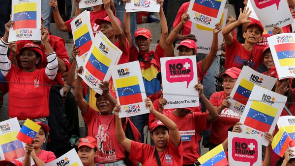 Caracas'ta Venezüella Devlet Başkanı Nicolas Maduro taraftarları ABD yaptırımlarını Trump karşıtı posterlerle protesto ederken - Sputnik Türkiye