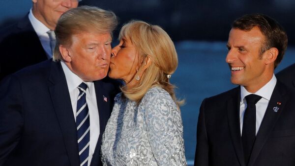 Fransa'nın Biarritz kentindeki G7 zirvesinde Fransa Cumhurbaşkanı Emmanuel Macron'un İran şokuna uğrayan ABD Başkanı Donald Trump'a aile fotoğrafı çekimi sırasında first lady Brigitte Macron öpücük kondurdu. - Sputnik Türkiye