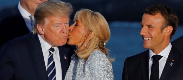 Fransa'nın Biarritz kentindeki G7 zirvesinde Fransa Cumhurbaşkanı Emmanuel Macron'un İran şokuna uğrayan ABD Başkanı Donald Trump'a aile fotoğrafı çekimi sırasında first lady Brigitte Macron öpücük kondurdu. - Sputnik Türkiye