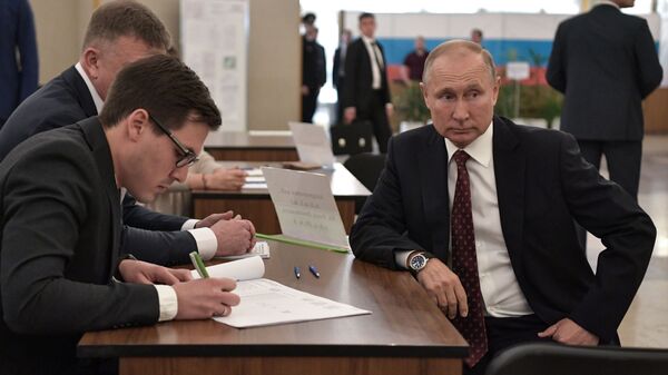 Rusya Devlet Başkanı Vladimir Putin seçim merkezinde yerel seçim komisyonuyla belge doldururken - Sputnik Türkiye