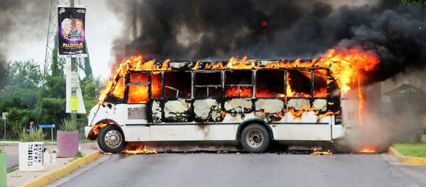  Ovidio Guzman Lopez’in yakalanması üzerine güvenlik güçleriyle çatışma başlatan kartel üyelei, ateşe verdikleri araçlarla yolları kapattı. - Sputnik Türkiye