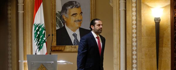 Suikasta kurban giden babası Refik Hariri'nin portresi önünde başbakanlıktan istifasını sunacağını açıklayan Saad Hariri, salondan çıkarken - Sputnik Türkiye