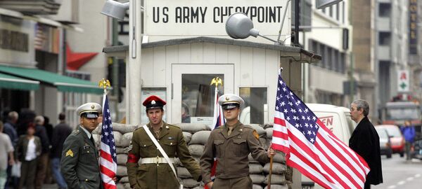 Almanya başkentindeki Berlin Duvarı'nın en meşhur geçiş noktası olan Charlie kontrol noktasında ABD askerlerini canlandıran aktörler - Sputnik Türkiye