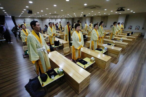 Güney Kore’de Hyowon Sağlık Merkezi, ölümü deneyimleyerek yaşamlarını daha da geliştirmek isteyen insanlar için ‘canlı cenaze’ törenleri düzenliyor.  - Sputnik Türkiye