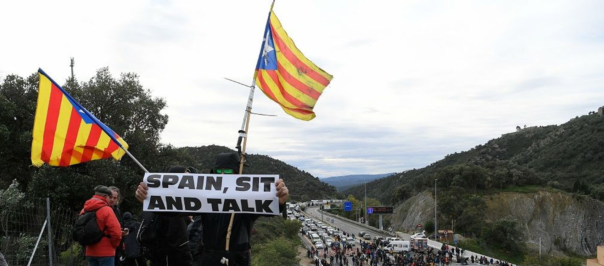 Katalonya'daki bağımsızlık girişimleriyle ilgili asla müzakere masasına oturmayacağını açıklayan İspanya'daki merkezi hükümete atfen, bazı eylemcilerin ellerinde İspanya, otur ve konuş yazılı pankartlar taşıdığı görüldü. - Sputnik Türkiye, 1920, 22.06.2021
