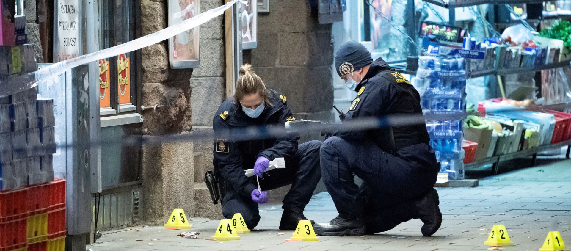 İsveç'in Malmö kentinin merkezindeki bir pizzacının önünde 15 yaşında bir genci öldüren, diğerini yaralayan silahlı saldırıyla ilgili polisin olay yeri araştırması - Sputnik Türkiye, 1920, 15.11.2019
