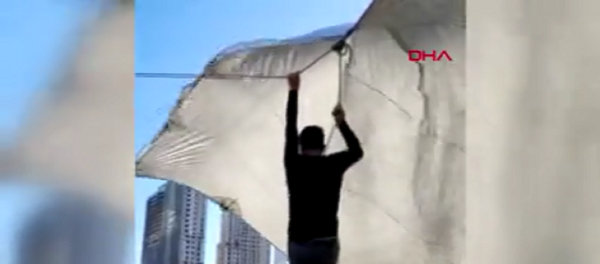 Kadıköy'de pazarcı çadır kurarken ip koptu. Şiddetli, rüzgar nedeniyle havalanan çadırın ipini bırakamayan pazarcı metrelerce yükseldi. O anlar cep telefonu kamerasına yansıdı. - Sputnik Türkiye