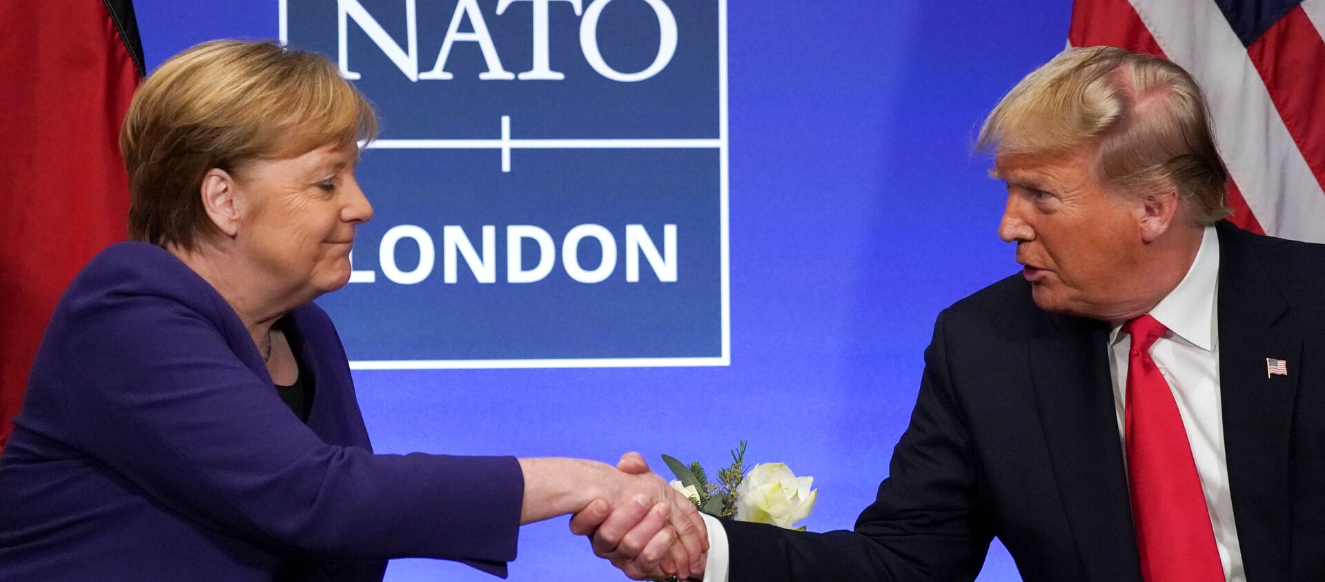U.S. President Donald Trump shakes hands with Germany's Chancellor Angela Merkel during a bilateral meeting at the sidelines of the NATO summit in Watford, Britain, December 4, 2019. REUTERS/Kevin Lamarque - Sputnik Türkiye, 1920, 11.07.2020