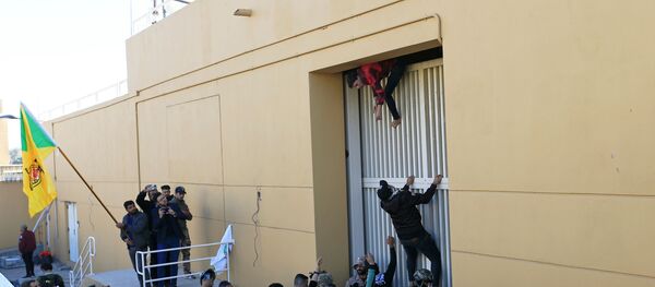 Hashd al-Shaabi (paramilitary forces) fighters try to enter the U.S. Embassy during a protest to condemn air strikes on their bases, in Baghdad, Iraq December 31, 2019. REUTERS/Thaier al-Sudani - Sputnik Türkiye