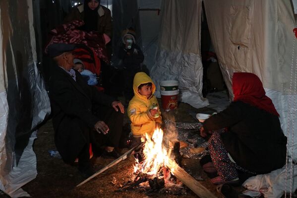 Çadırların önünde ateş yakarak ısınmaya çalışan vatandaşlar, bu sorunlarına çözüm bulunmasını istiyor.  - Sputnik Türkiye