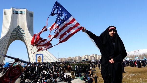 Tahran'daki Azadi Meydanı'nda İran İslam Devrimi 41. yıldönümü törenleri sırasında bir kadın yanmış ABD bayrağı sallarken - Sputnik Türkiye
