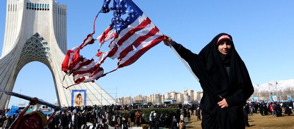 Tahran'daki Azadi Meydanı'nda İran İslam Devrimi 41. yıldönümü törenleri sırasında bir kadın yanmış ABD bayrağı sallarken - Sputnik Türkiye