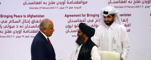 ABD - Taliban barış anlaşmasını imzalayan ABD'nin Özel Temsilcisi Zalmay Halilzad ve Taliban Siyasi Ofisi Direktörü Molla Abdul Gani Baradar - Sputnik Türkiye