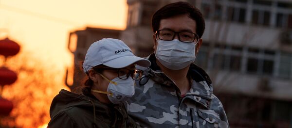 Çin başkenti Pekin'de koronavirüs önlemi olarak maskeyle dolaşan bir çift - Sputnik Türkiye