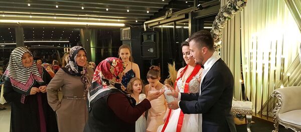 Gelin ve damat, davetlilerin ellerine takı takmadan önce dezenfektan sıktı. - Sputnik Türkiye