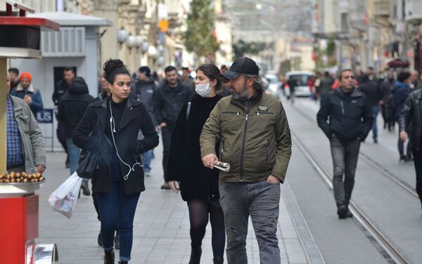 Vatandaşlar dışarı çıkarken koruyucu maske takarak önlem alıyor. - Sputnik Türkiye