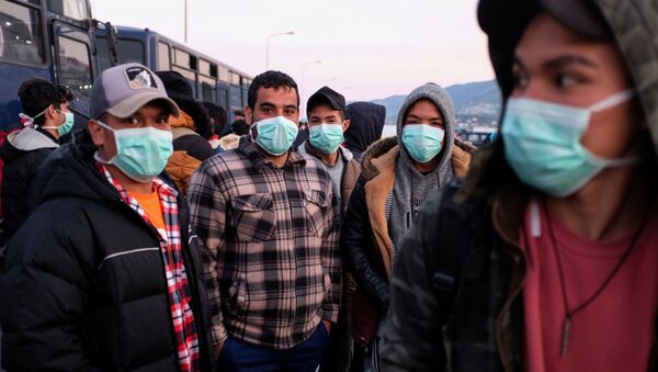 Yunanistan'da tutulan ve koronavirüs önlemi olarak maske takan göçmenler, Midili Adası'nda kendilerini anakaraya nakledecek feribotu beklerken - Sputnik Türkiye