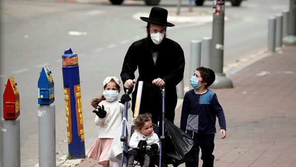 İsrail'de koronavirüsün en çok vurduğu yer olan ve karantinaya alınan Bnei Brak'ta maskeli dolaşan bir ultra-Orthodoks Yahudi aile - Sputnik Türkiye