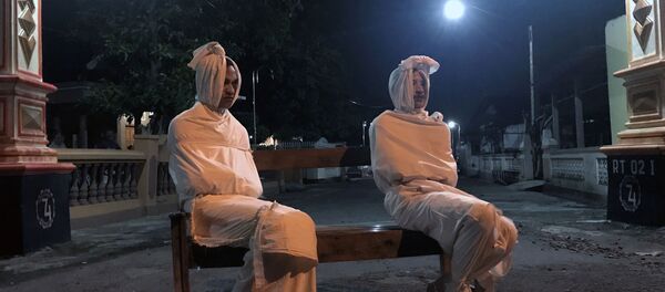 Endonezya’da koronavirüs salgınına karşı insanları evde tutmak isteyen bir köy ‘hayaletlerden’ medet umuyor. Yüzleri beyaza boyanan ve kefene benzeyen beyaz kıyafetler giydirilen gönüllüler, dışarı çıkanları korkutmayı ve evlere sokmayı amaçlıyor. - Sputnik Türkiye