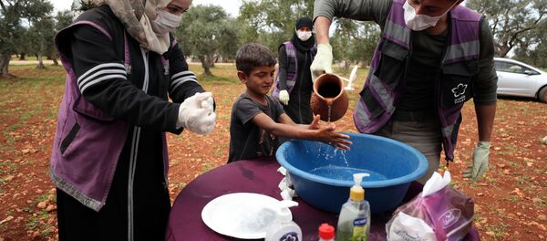 Suriye-Gönüllüler, koronavirüs tedbirleri kapsamında mültecilere ellerini nasıl yıkayacağını öğretiyor. - Sputnik Türkiye