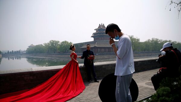 Çin - 720 bin metrekarelik alanı kaplayan ve ülkedeki saraylar arasında en bilineni olan ''Yasak Şehir dışında bir çift düğün fotoğraflarını çektiriyor. - Sputnik Türkiye