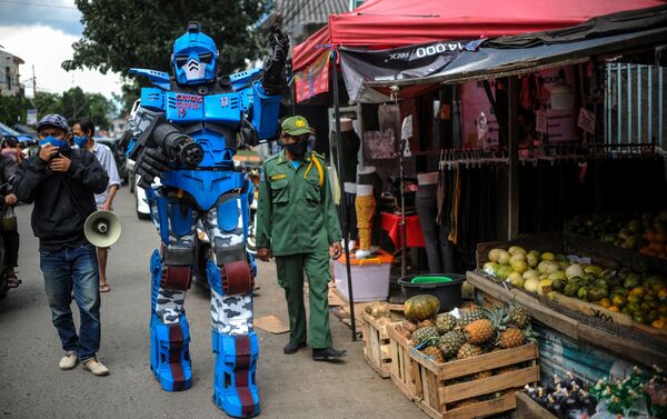Gönüllülerden biri de üzerinde 'Covid-19' yazan bir Transformers kostümü giyerek dolaştı. - Sputnik Türkiye