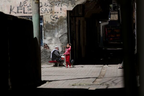 Bağlar’ın ara sokaklarında yaşayanlar yaşlılar ise sokakta güneşlenerek zaman geçirdi. - Sputnik Türkiye